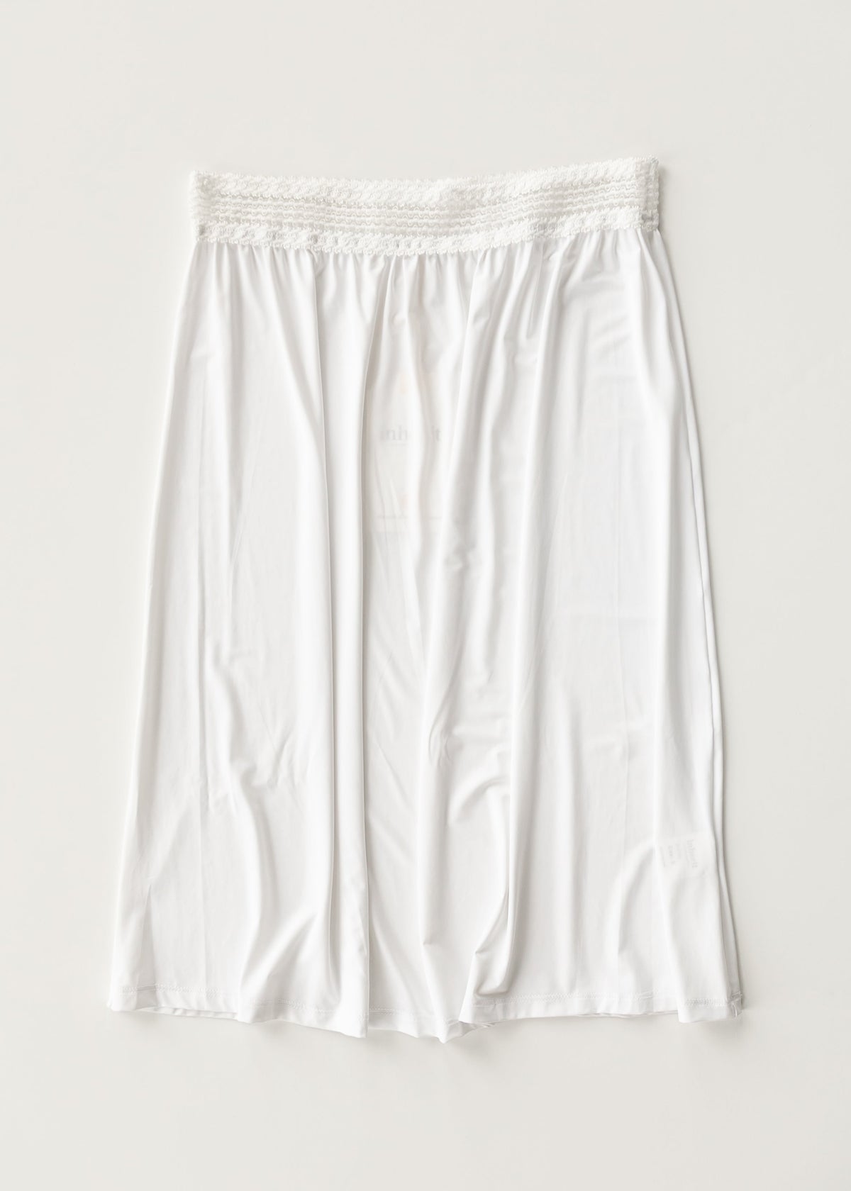 White half slip with elastic waistband and gathered skirt, mid-thigh length