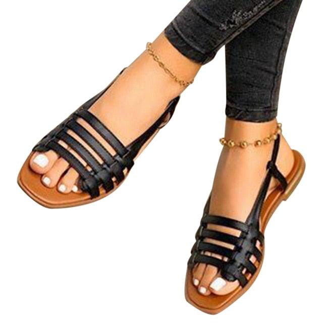 Black strappy flat sandals with open toe and ankle slingback