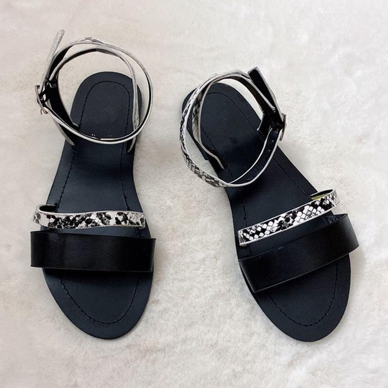 Black strappy flat sandals with snake-print trim and open toe