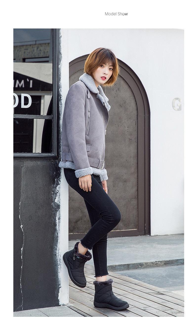 Gray winter ankle boots with plush shearling lining and zip front, on model
