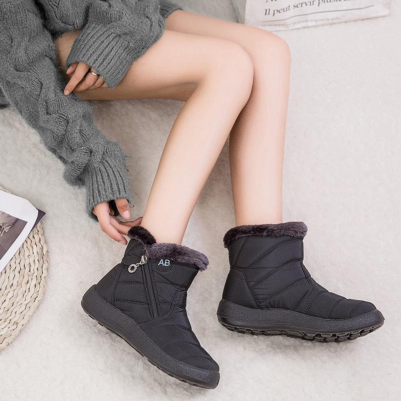 Women’s winter ankle boots, black quilted with faux-fur cuffs and side zipper, worn on feet