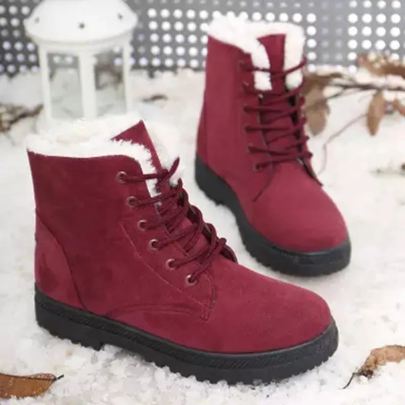 Red ankle boots with lace-up design, white faux-fur cuff, and chunky rubber outsole