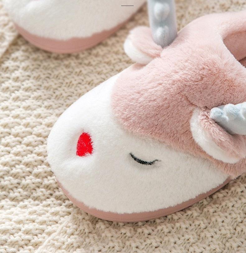 Close-up of pink animal-face slipper with red heart detail and plush toe cap