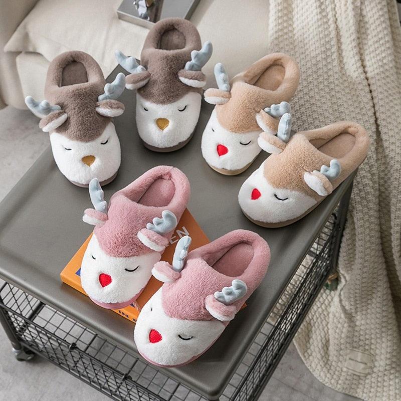Assorted plush animal-face slippers displayed in a tray, closed toe and fuzzy cuffs