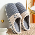Blue ribbed slippers with white sherpa trim, open slip-on shape, and bear emblem