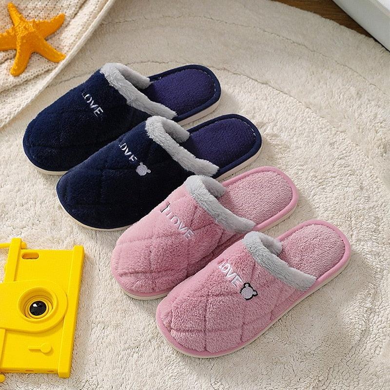 Navy and pink plush house slippers with fuzzy lining, slip-on style, and bear emblem