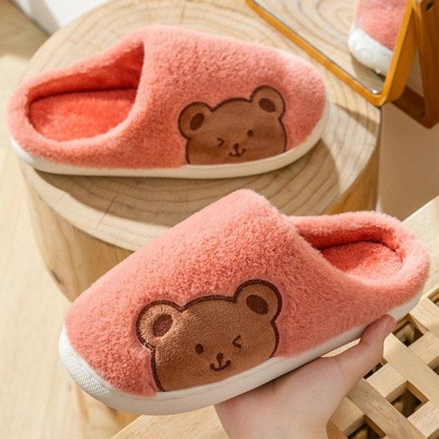 Pink plush house slippers with bear face applique and cushioned sole