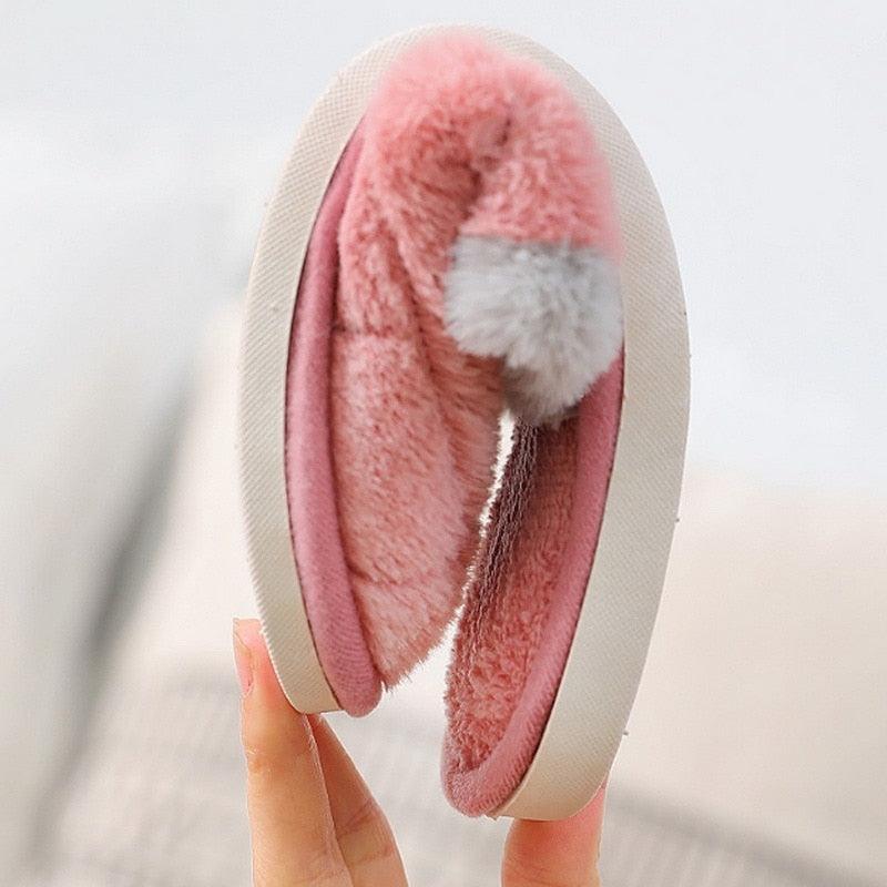 Pink plush fur-lined slip-on slippers with white cuff and cartoon bear patch