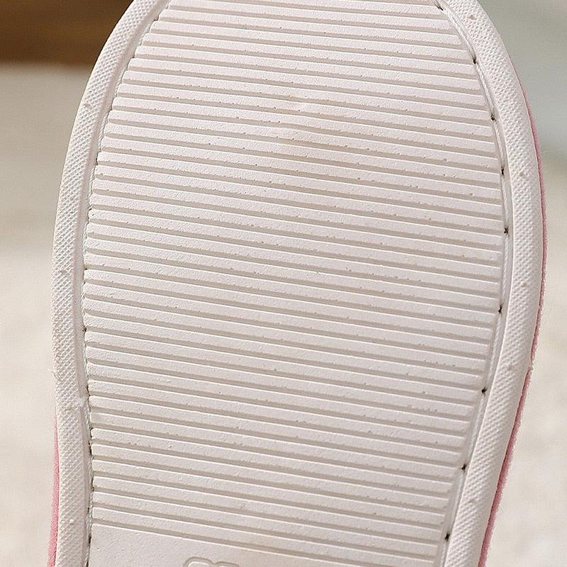 Grey rubber outsole with parallel tread lines under a slipper