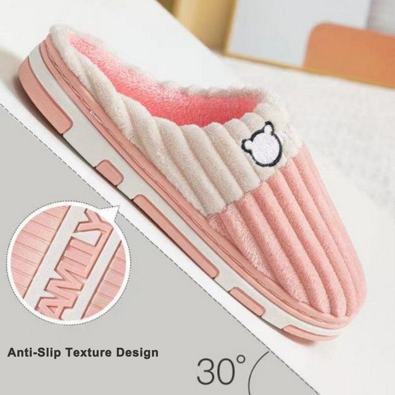 Light pink slide slippers with white sherpa lining, ribbed texture, and bear emblem