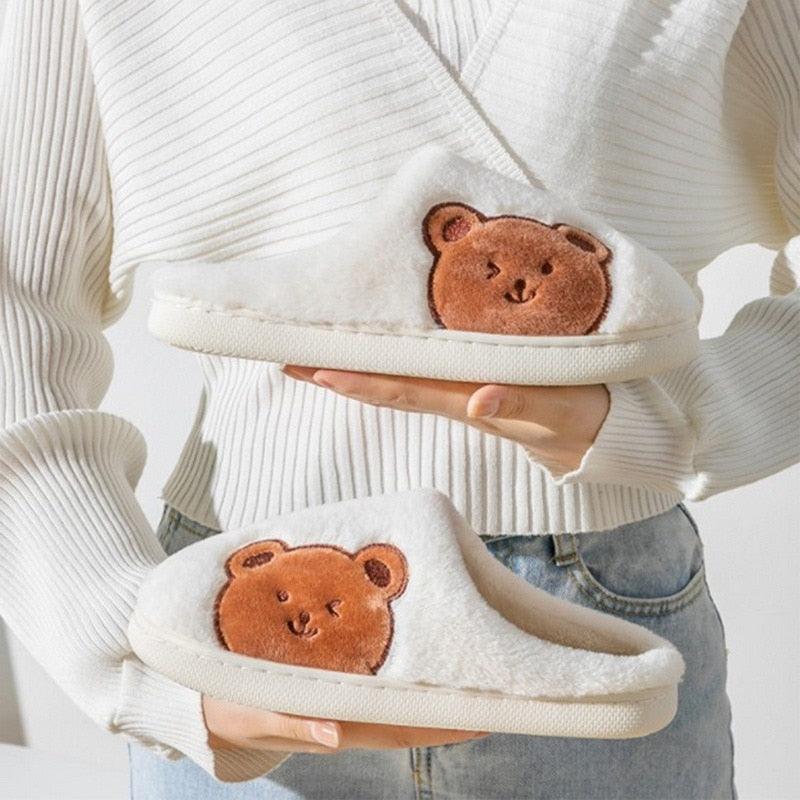 White plush house slippers with brown bear applique and cushioned sole