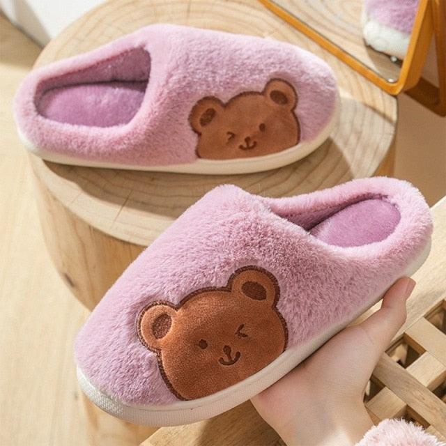 Pink fleece slippers with brown cartoon bear face patch and soft cushioned sole