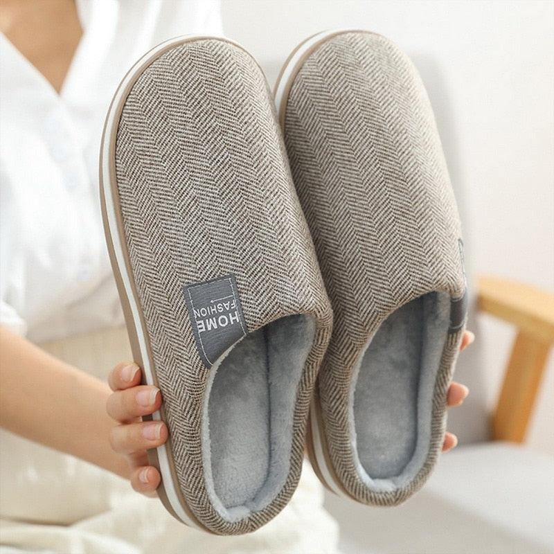 Grey herringbone house slippers with light blue fuzzy lining and cushioned sole