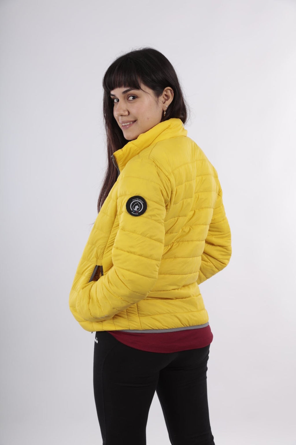 Yellow alpaca puffer jacket side view with hood and full-zip, worn by model