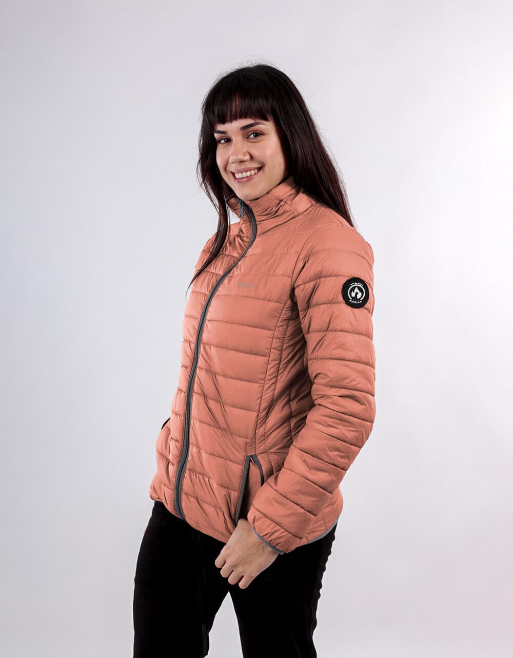 Orange women's quilted puffer jacket with full-zip front and round logo patch