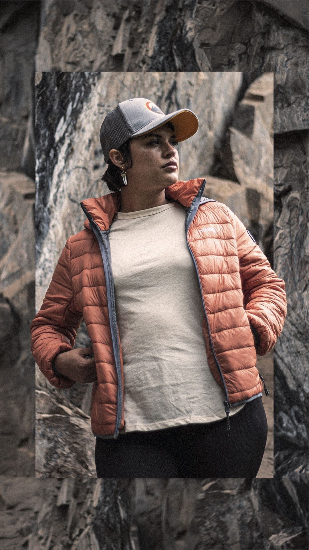 Orange women's quilted puffer jacket with full-zip front, hood, and logo patch