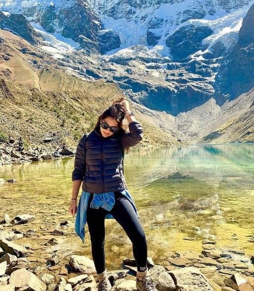 Women’s puffer alpaca jacket in dark gray/black with full-zip, worn outdoors near a glacier