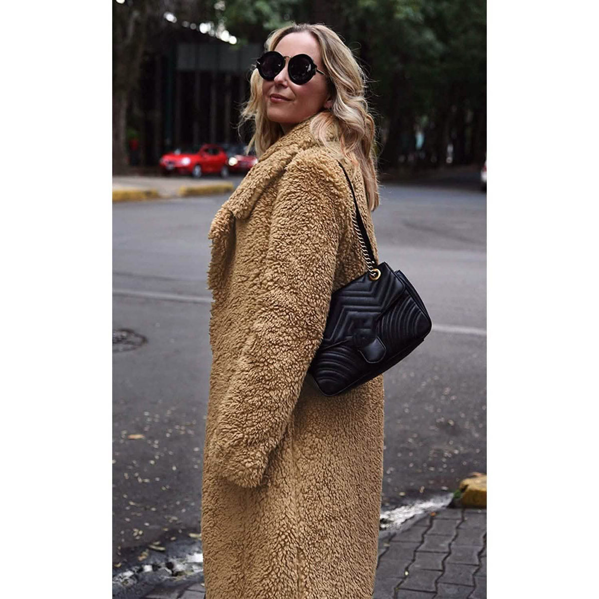 Women's fuzzy fleece lapel open-front long coat, tan teddy texture, side view.