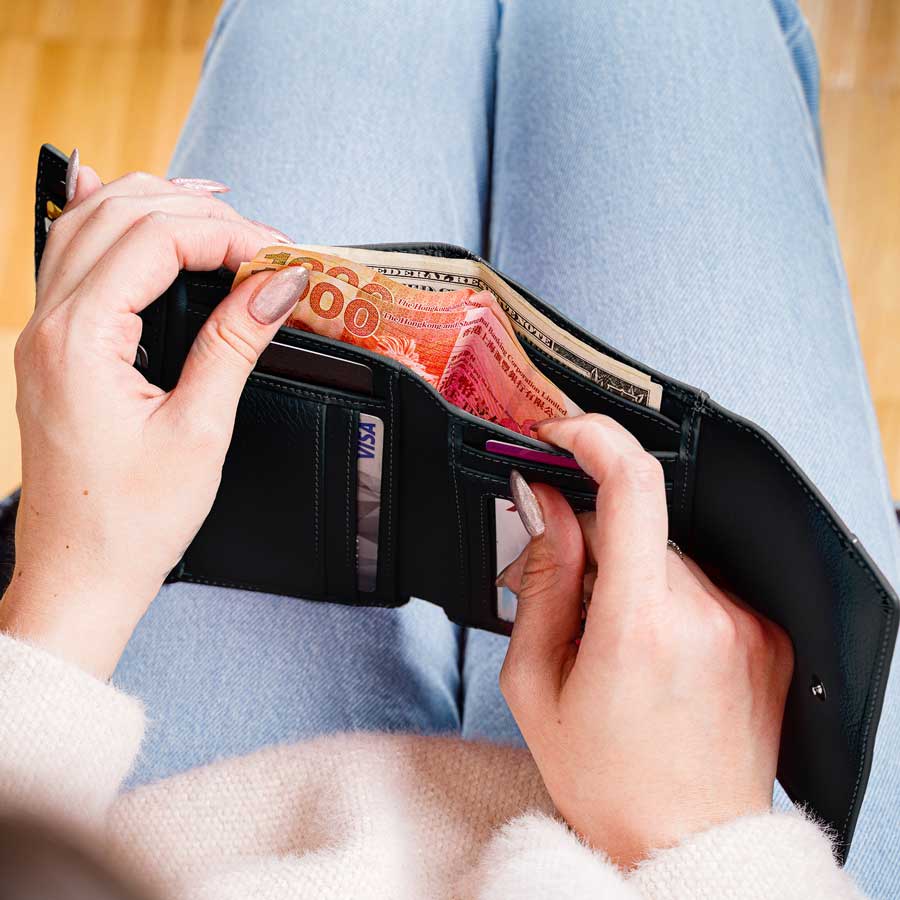 Black leather trifold wallet open with card slots and cash