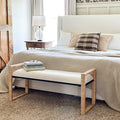 Woven rattan wooden bench with light wood frame and beige upholstered seat cushion