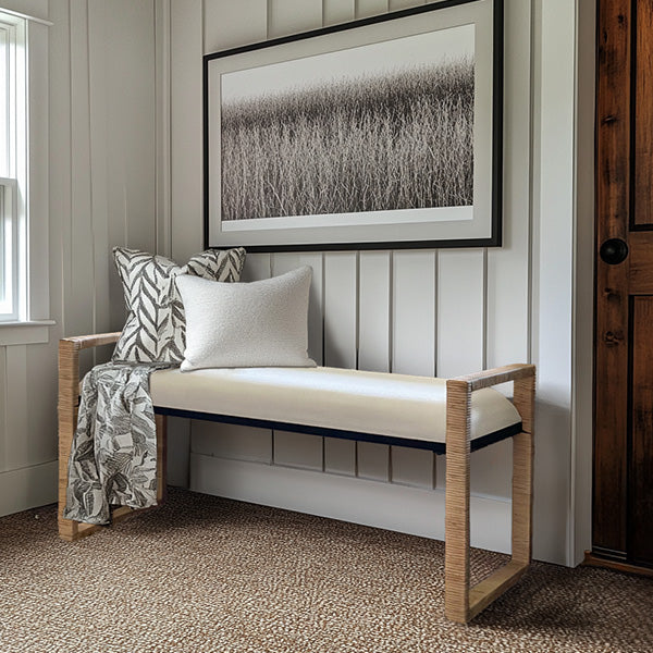 Woven rattan wooden bench with cream seat cushion and light wood frame