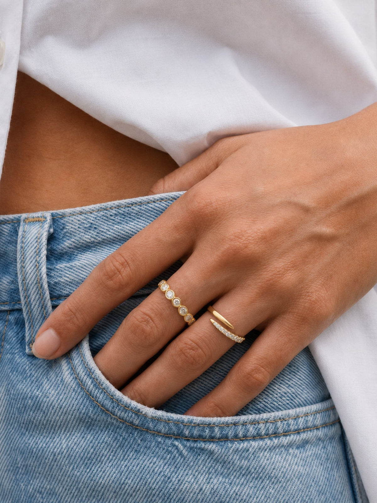 Gold filled pavé spiral ring worn on a hand with a beaded gold band