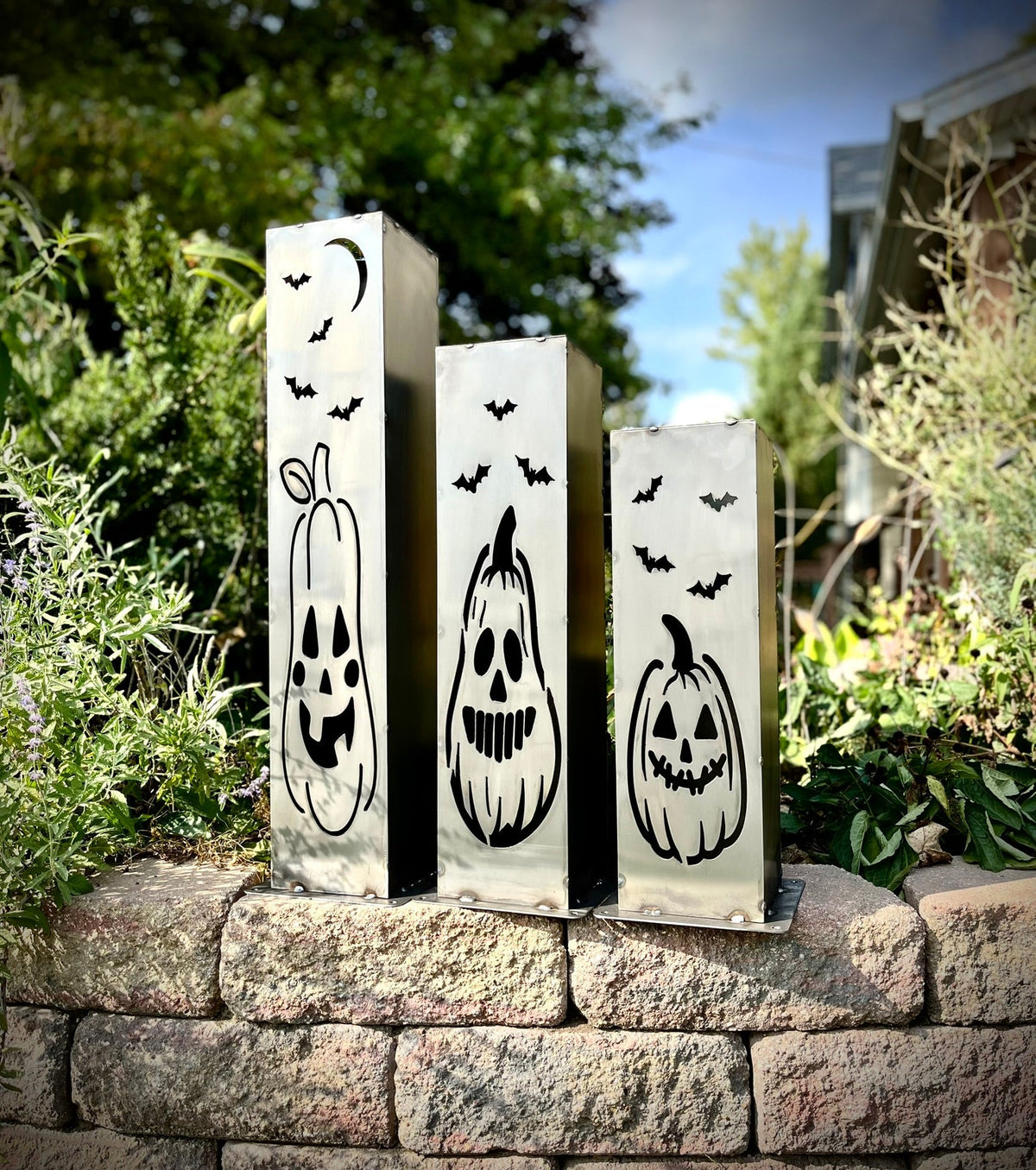 Set of three steel solar pillar lights with black bat and jack-o-lantern faces
