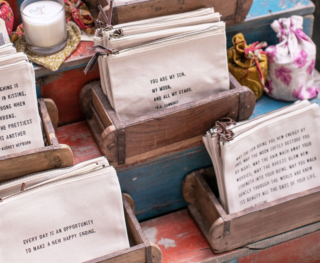 Set of canvas zip pouches with Maya Angelou quote prints in front view.