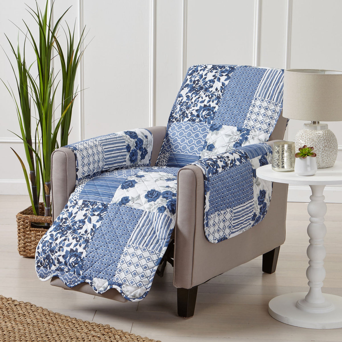 Reversible armchair protector in blue and white patchwork floral, arranged over beige upholstery.