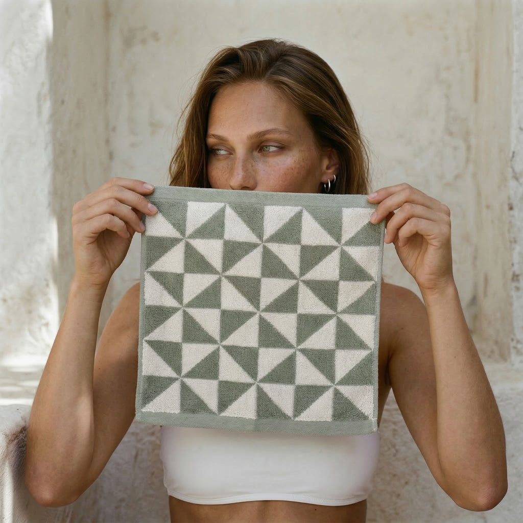 Sage green and ecru geometric-pattern cotton towel held up by model