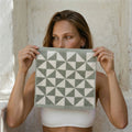 Sage green and ecru geometric-pattern cotton towel held up by model
