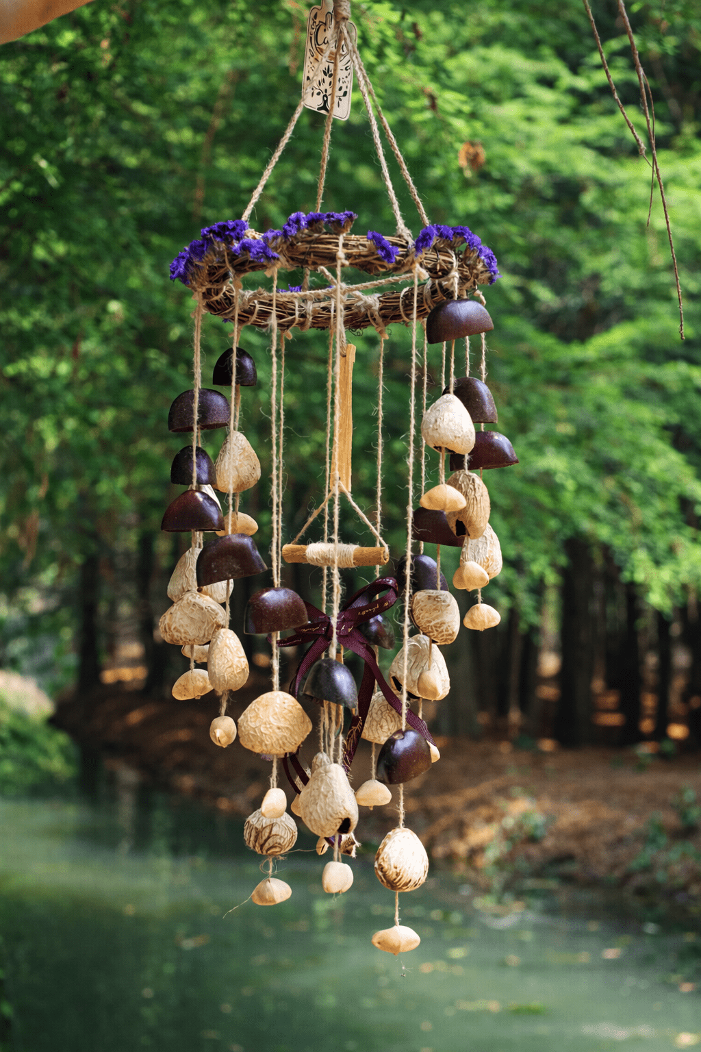 Vine wreath seed chime with purple flowers and hanging beige seed pods