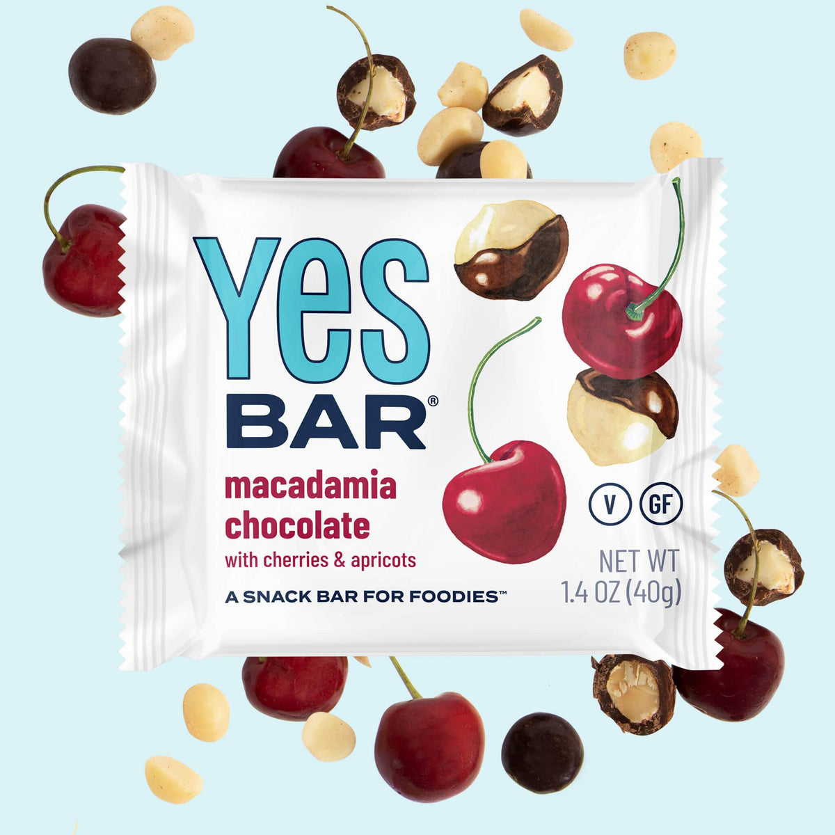 Macadamia chocolate snack bar pouch with cherries and nut pieces surrounding it