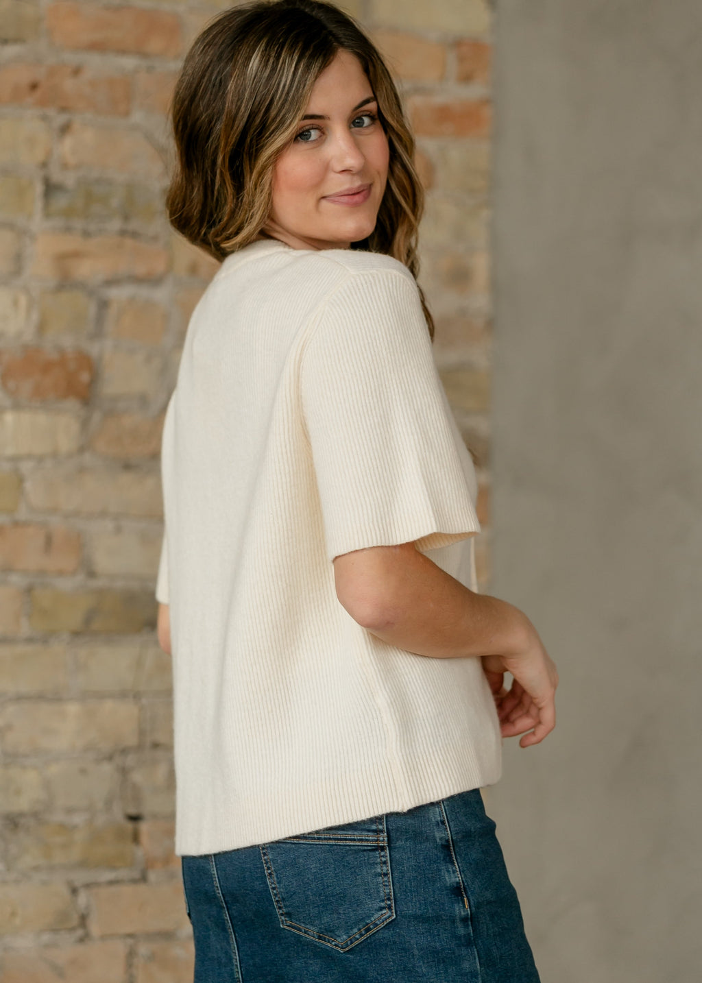 Ivory short-sleeve button cardigan with open neckline and ribbed knit side detail
