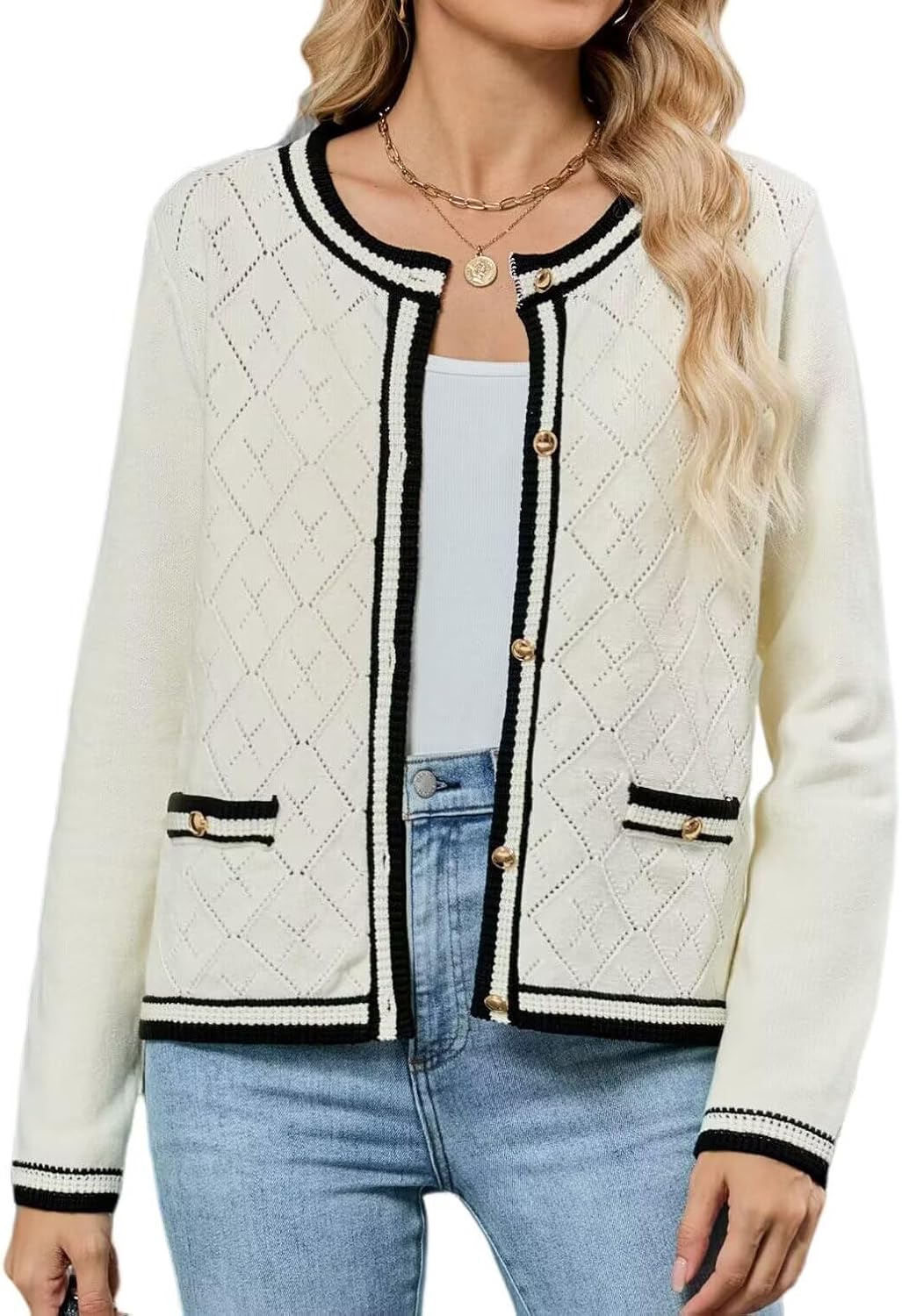 Cream cardigan sweater with black edging, gold-tone button front, two chest pockets.
