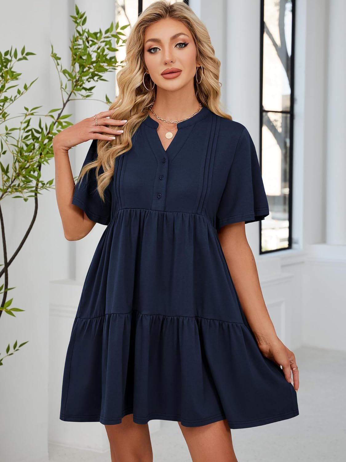 Navy blue V-neck babydoll dress with short flutter sleeves and tiered ruffle skirt