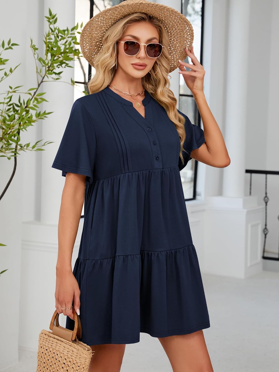 Navy blue V-neck babydoll dress with button front, flutter sleeves, and tiered skirt