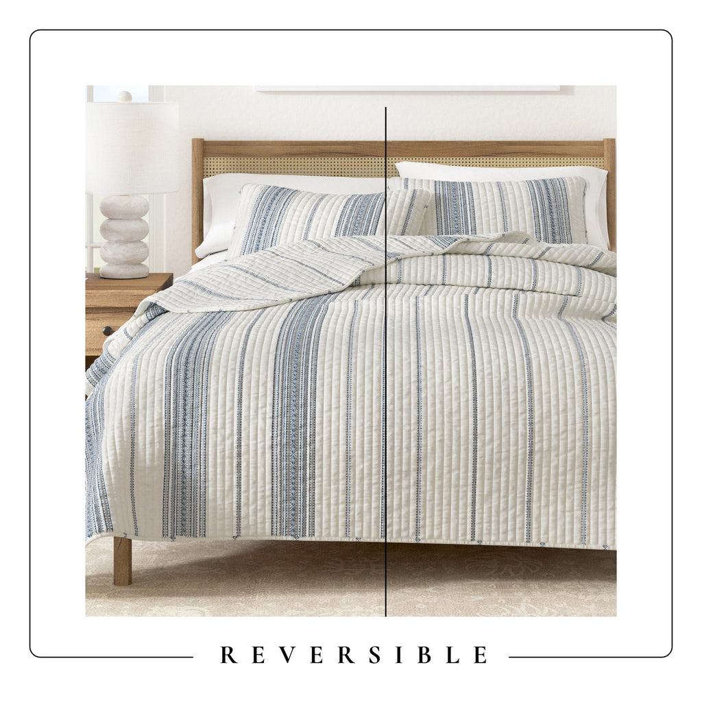 Reversible striped quilt display showing cream and navy vertical stripes on both sides.