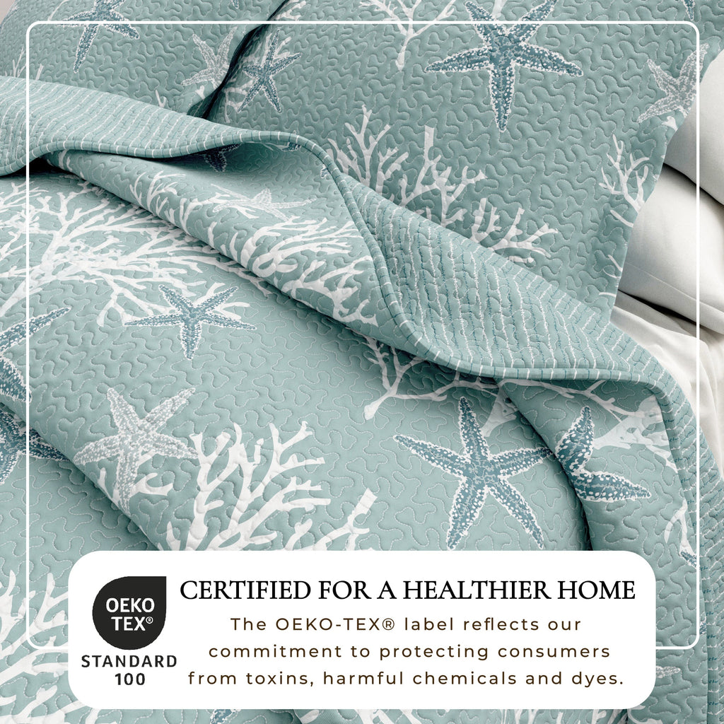 Light blue quilt close-up with starfish and coral motif and quilted texture.